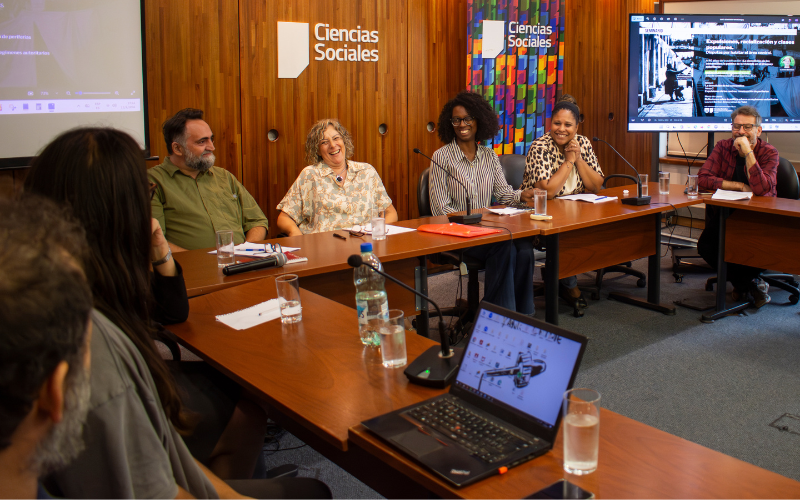Seminario «Expulsiones, racialización y clases populares. Disputas por habitar el área central» En el salón L5 están dispuestas las mesas en forma de de U. En el escritorio central se encuentran Alejandro Gortázar, Mónica Olaza, Fernanda Olivar y Noelia Maciel.